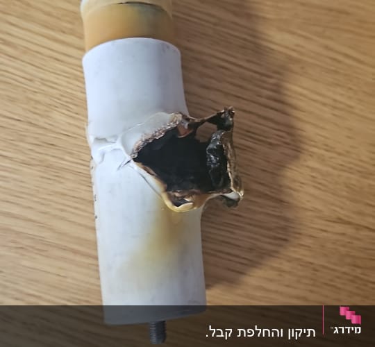 רכיב שרוף עם חור גדול על משטח עץ